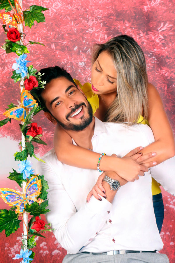 Pareja podando para sesión fotográfica sentada en un columpio