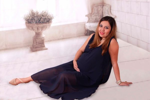 muchacha embarazada vestida de azul sentada en el suelo
