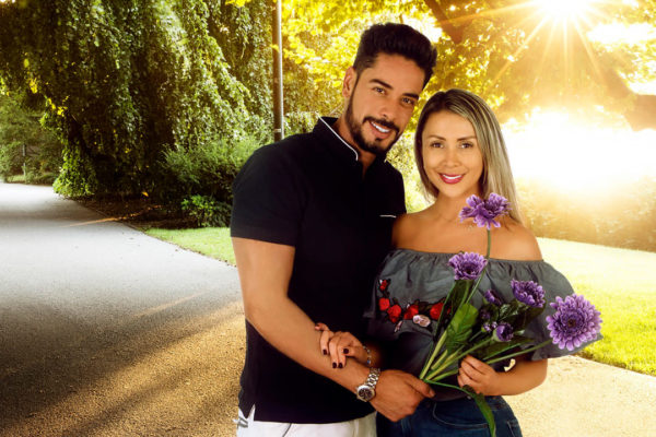 pareja posando en sesión fotográfica sosteniendo un ramo de flores